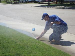 a North Highlands Irrigation Repair tech adjusts a sprinkler head